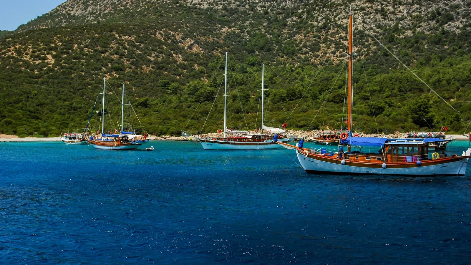 Ortakent sahilinde çocuklarıyla kumda oynayan aile